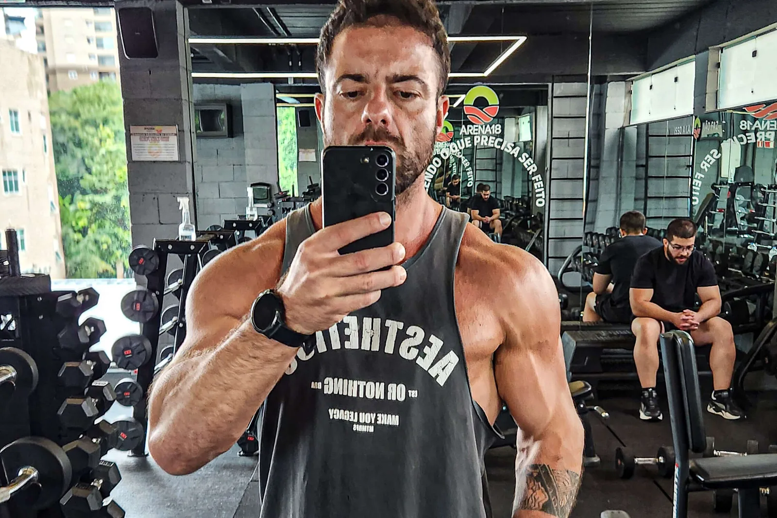 Montinho Personal Trainer na Arena 18 Alphaville: área de musculação com halteres, máquinas e vista para a cidade